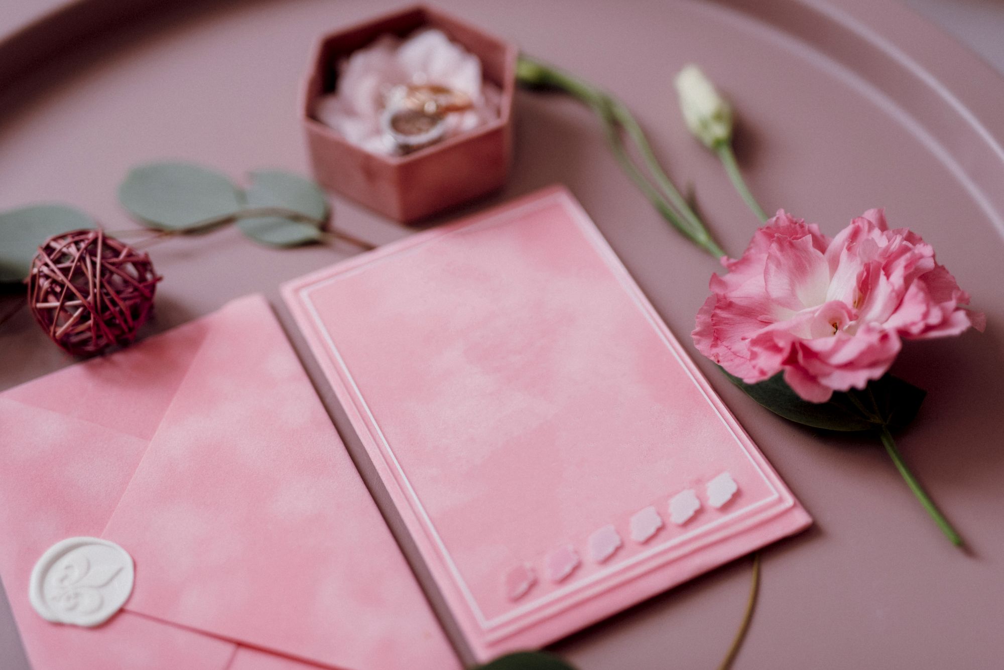 Blush pink wedding invitation with wax-sealed envelope, ring box and florals